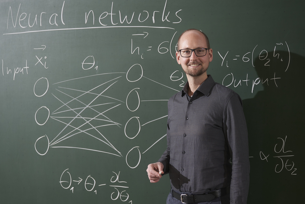 Pascal Friderich vor Tafel mit Formeln zu neuronalen Netzwerken